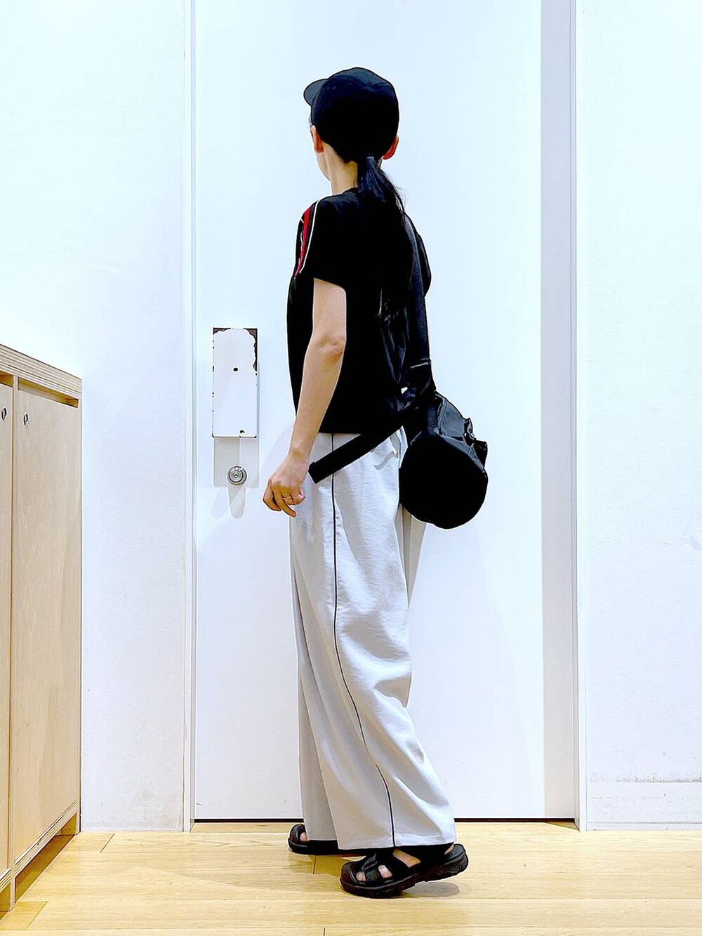 ブラック系のショルダーバッグ、ブラック系のスリッポン、ブラック系のTシャツ/カットソーを着用したレディースの春コーディネートの3枚目の写真