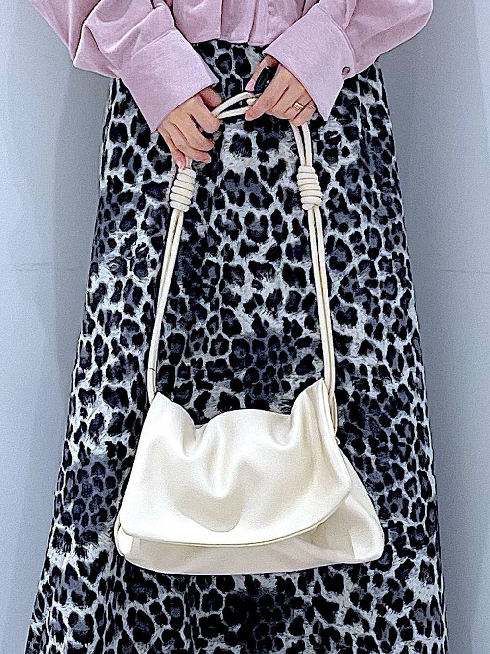 ホワイト系のショルダーバッグ、ブラック系のブーツ、グレー系のスカートを着用したレディースの秋コーディネートの9枚目の写真