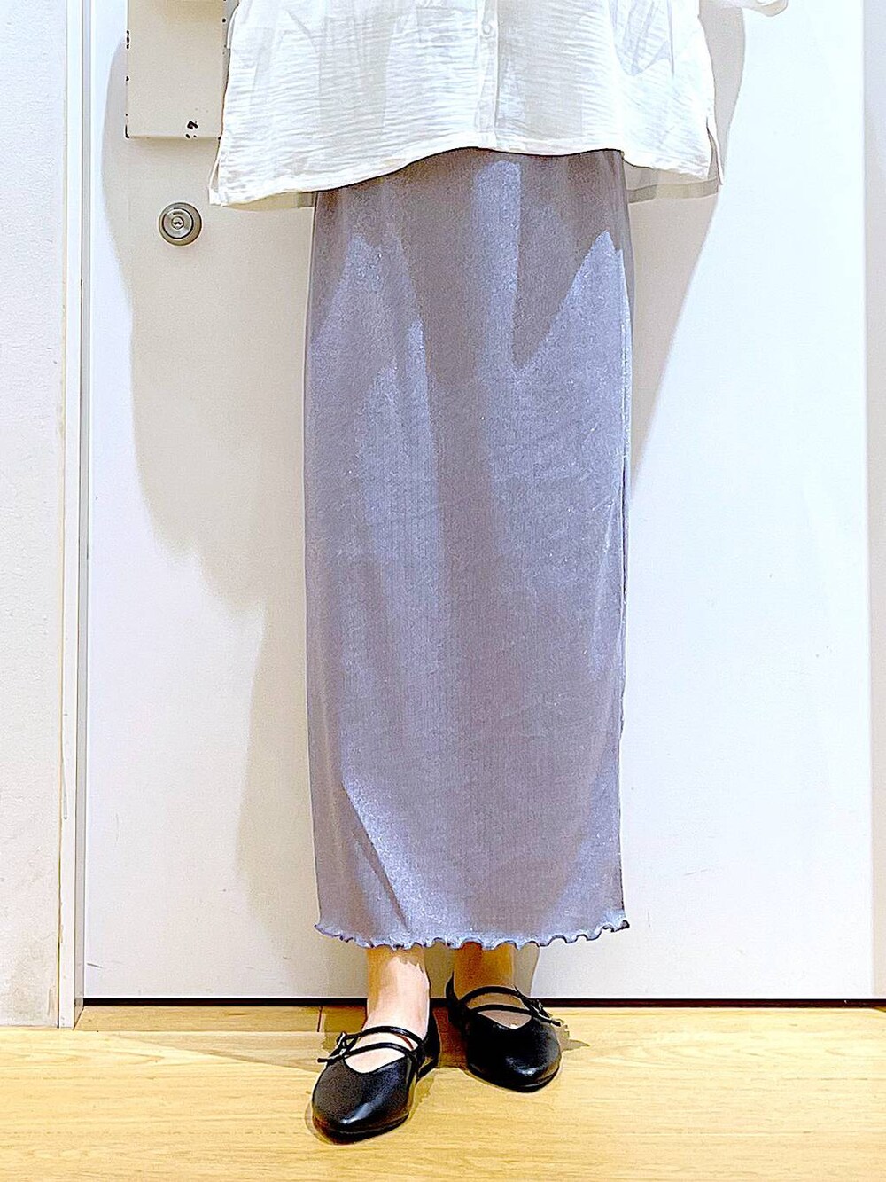 パープル系のスカート、ブラック系のショルダーバッグ、ブラック系のパンプスを着用したレディースの秋コーディネートの8枚目の写真