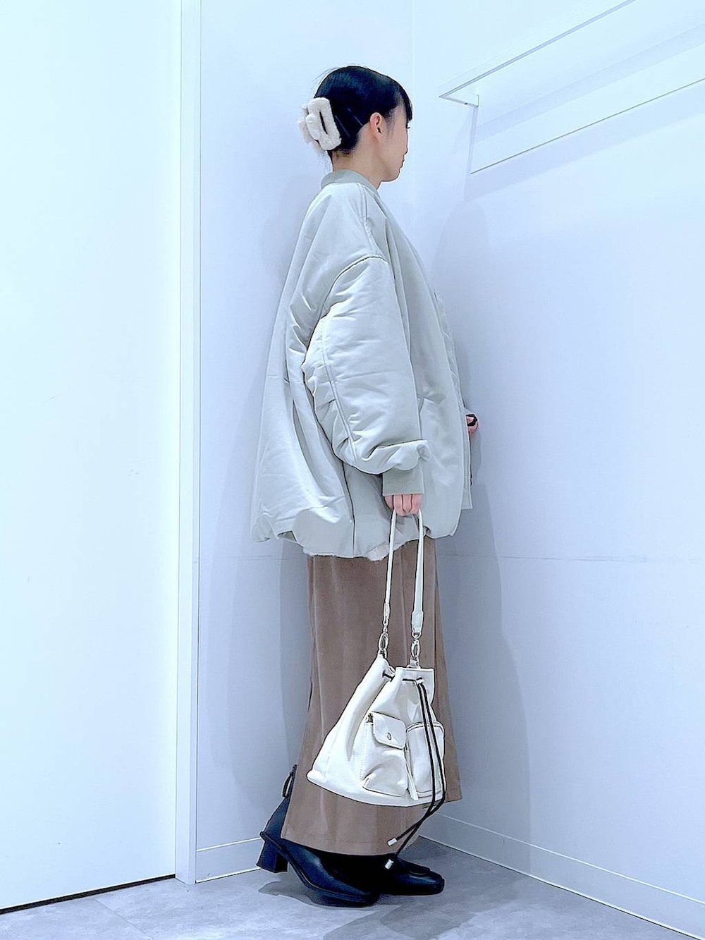 ベージュ系のニット/セーター、ブラック系のブーツ、ブラウン系のスカートを着用したレディースの冬コーディネートの4枚目の写真