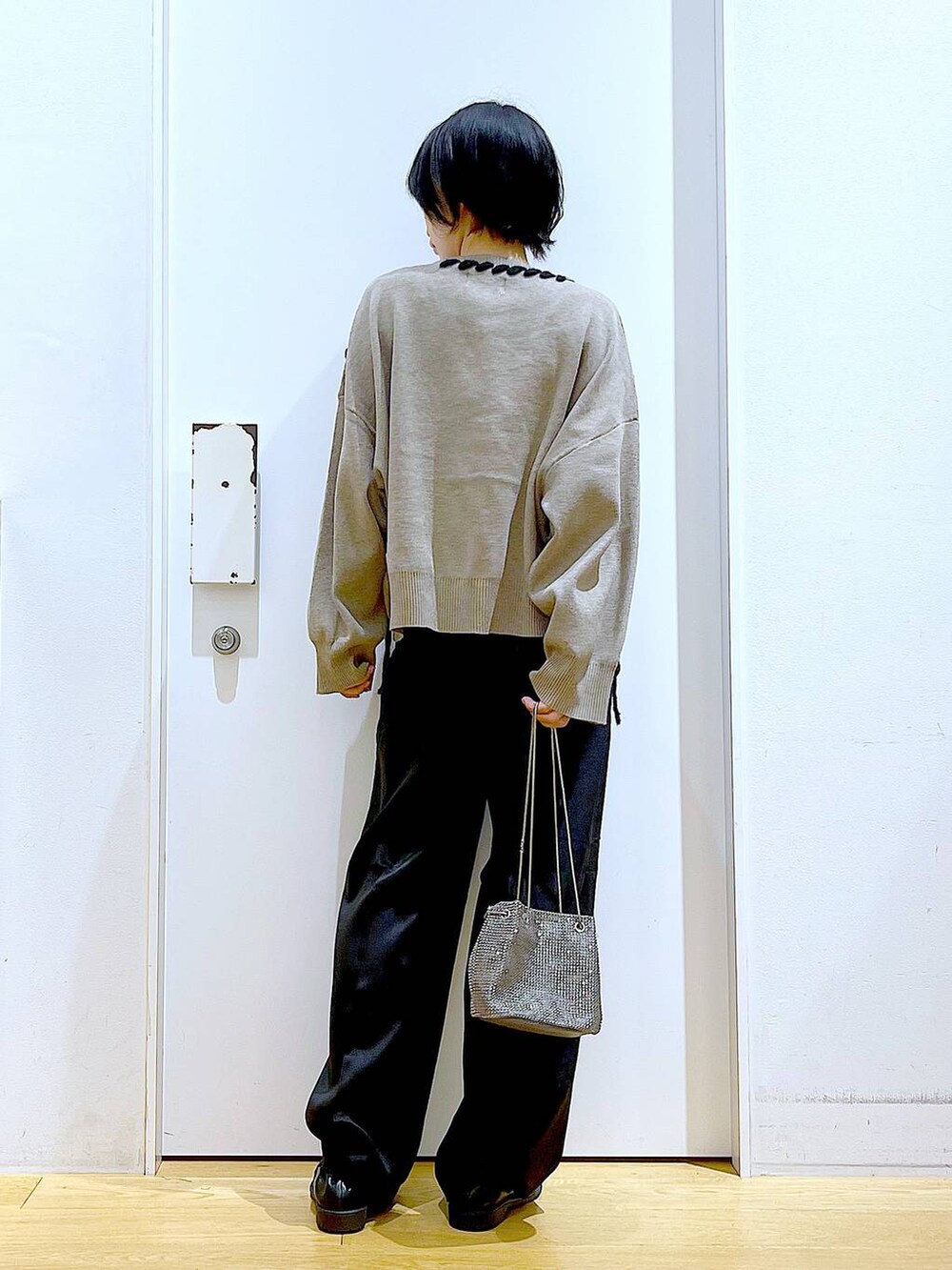 グレー系のショルダーバッグ、ブラック系のローファー、ブラウン系のニット/セーターを着用したレディースの冬コーディネートの5枚目の写真