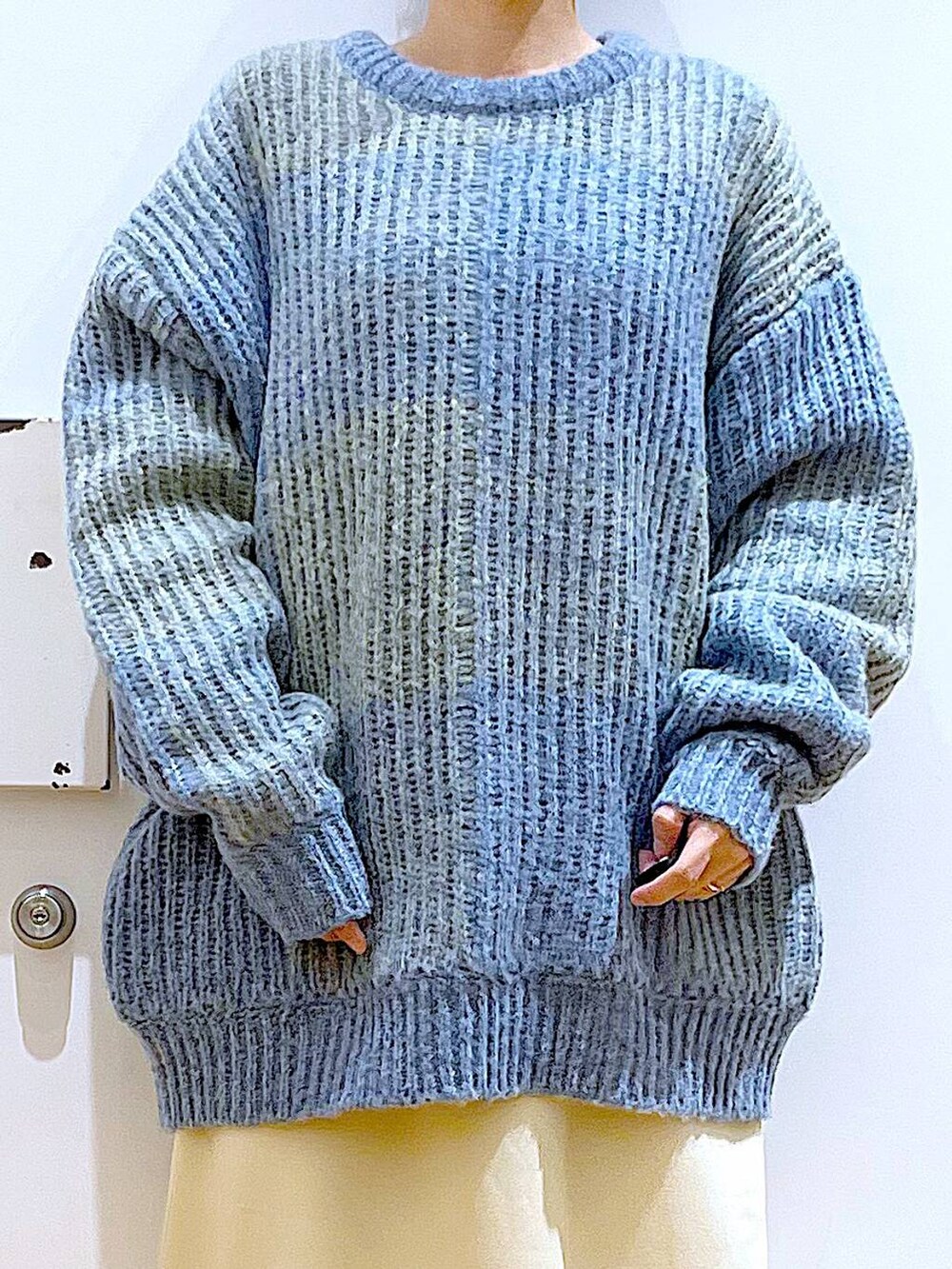 ブルー系のニット/セーター、ブラック系のブーツ、シルバー系のショルダーバッグを着用したレディースの冬コーディネートの7枚目の写真