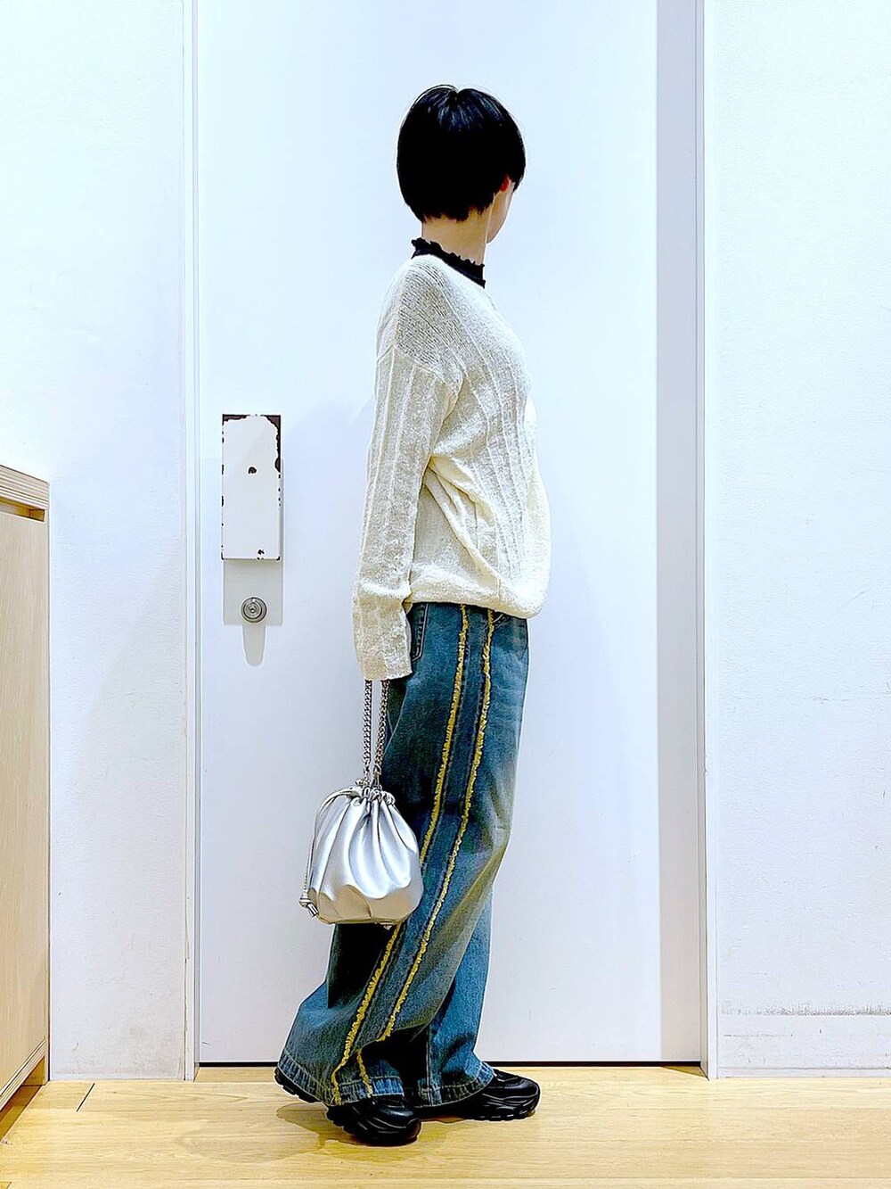 ブラック系のTシャツ/カットソー、シルバー系のショルダーバッグ、ブラック系のスニーカーを着用したレディースの春コーディネートの4枚目の写真