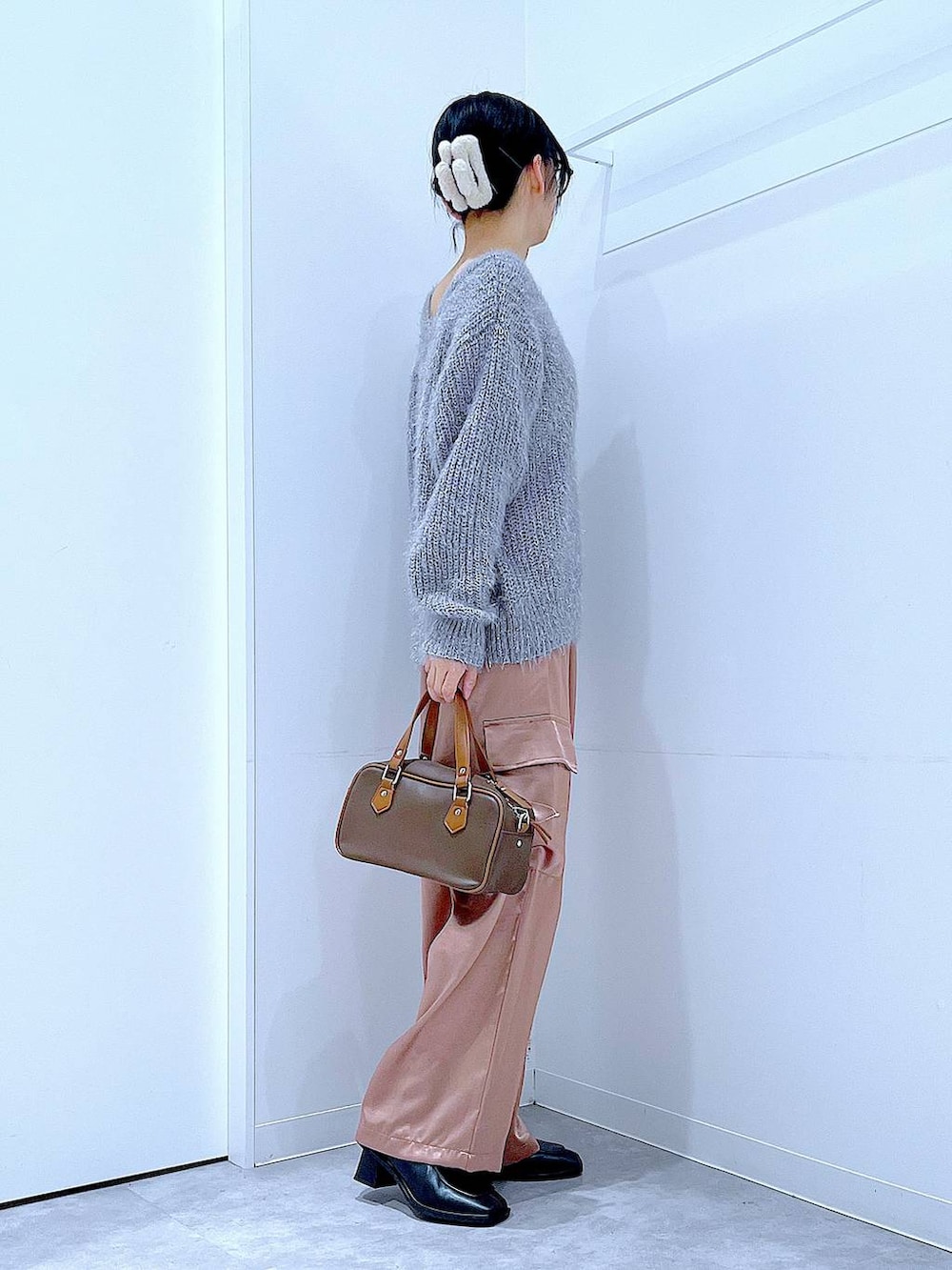 ブラック系のブーツ、ブラウン系のショルダーバッグ、ピンク系のカーゴパンツを着用したレディースの冬コーディネートの4枚目の写真