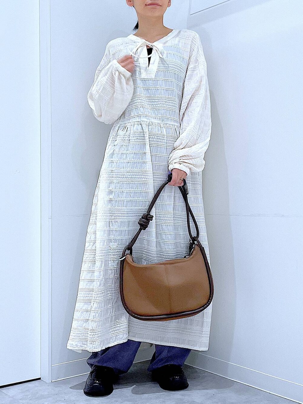 ブラック系のローファー、ブラウン系のショルダーバッグ、ベージュ系のワンピースを着用したレディースの秋コーディネートの6枚目の写真