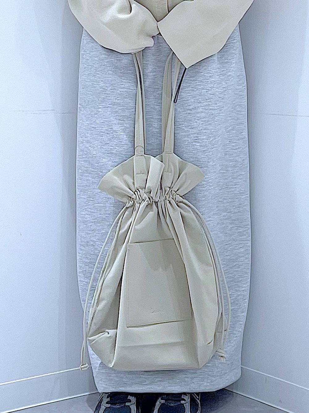 ブラック系のTシャツ/カットソー、ベージュ系のトートバッグ、グレー系のスカートを着用したレディースの冬コーディネートの9枚目の写真