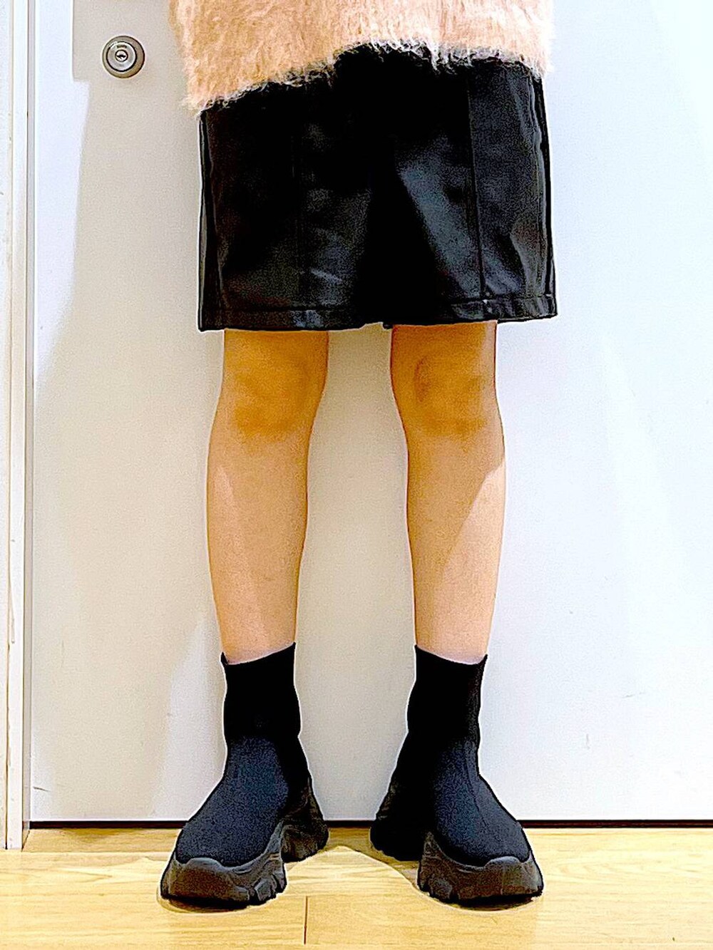 ピンク系のニット/セーター、ブラック系のブーツ、ブラック系のショルダーバッグを着用したレディースの冬コーディネートの8枚目の写真