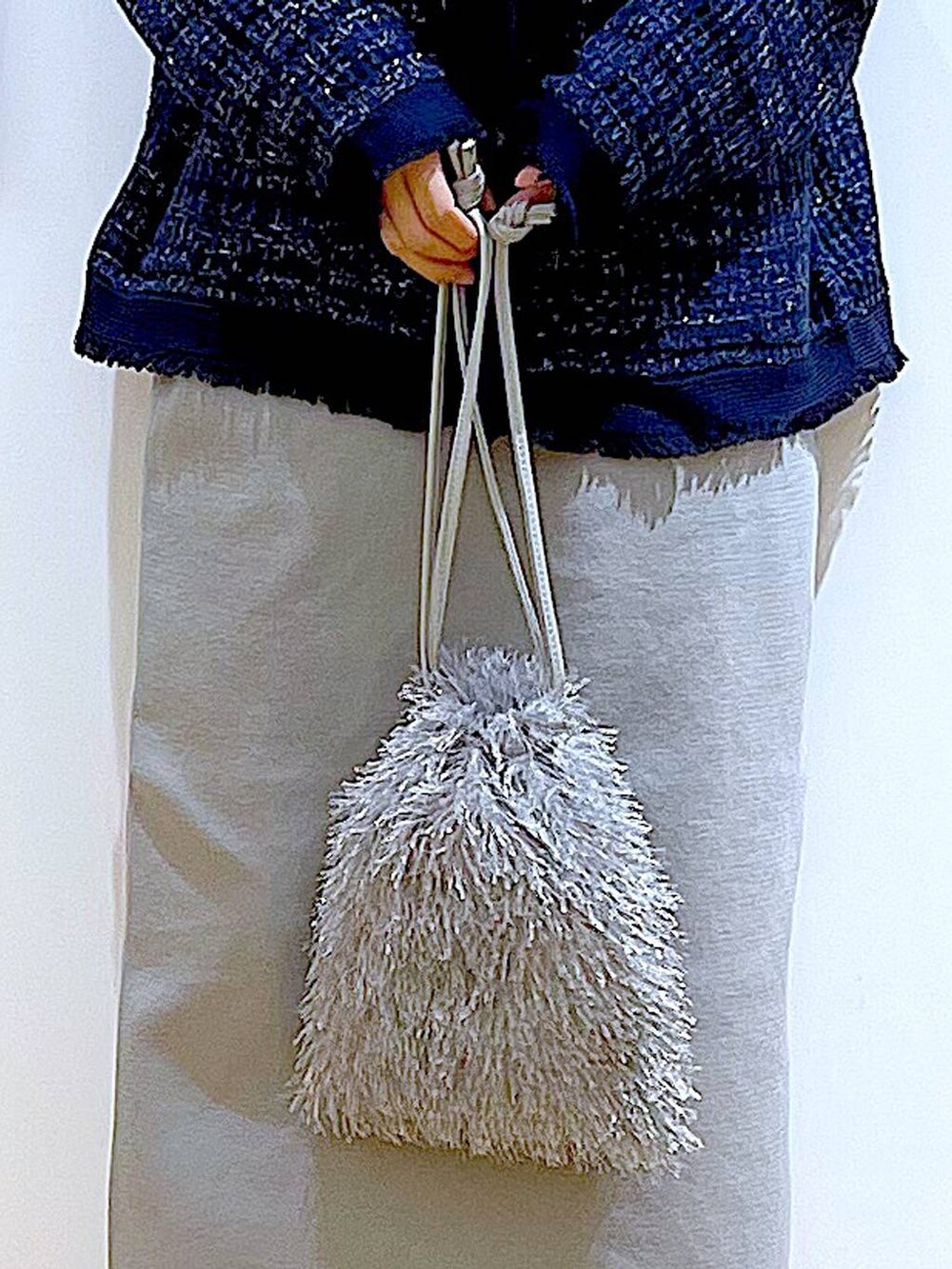 グレー系のTシャツ/カットソー、ブルー系のカーディガン/ボレロ、ベージュ系のブーツを着用したレディースの春コーディネートの9枚目の写真