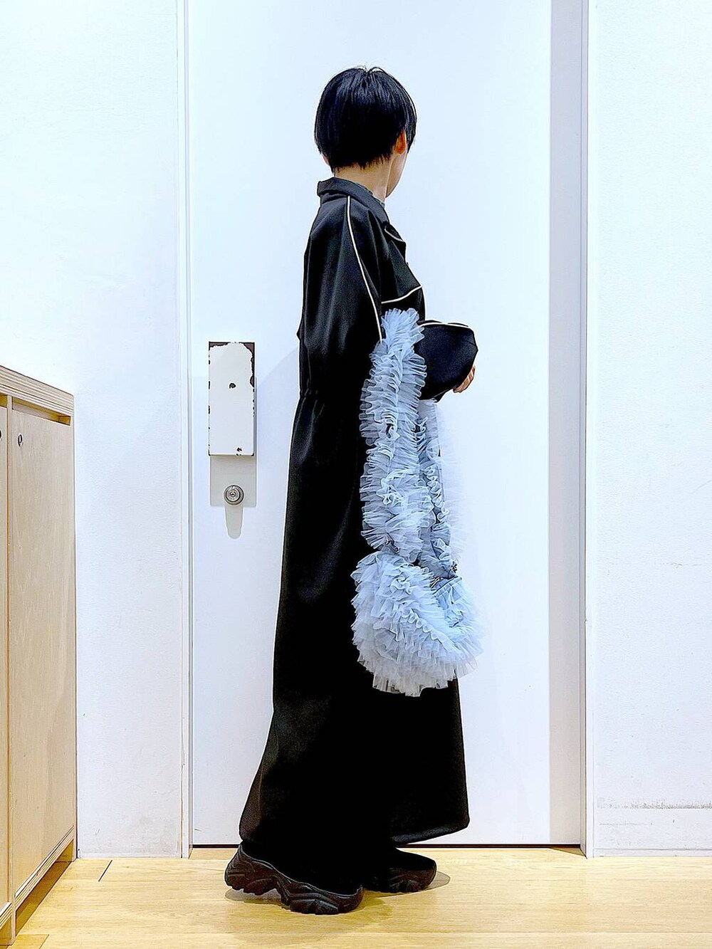 ブラック系のブーツ、ブルー系のショルダーバッグ、ブルー系のニット/セーターを着用したレディースの冬コーディネートの4枚目の写真