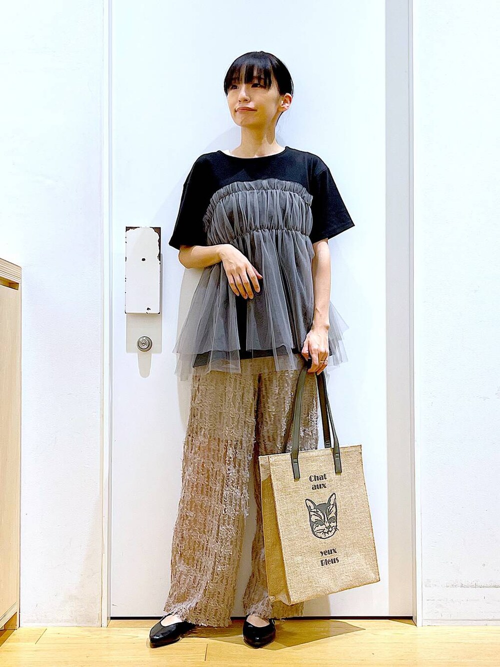 ブラック系のTシャツ/カットソー、ブラック系のパンプス、グレー系のトートバッグを着用したレディースの夏コーディネートの2枚目の写真