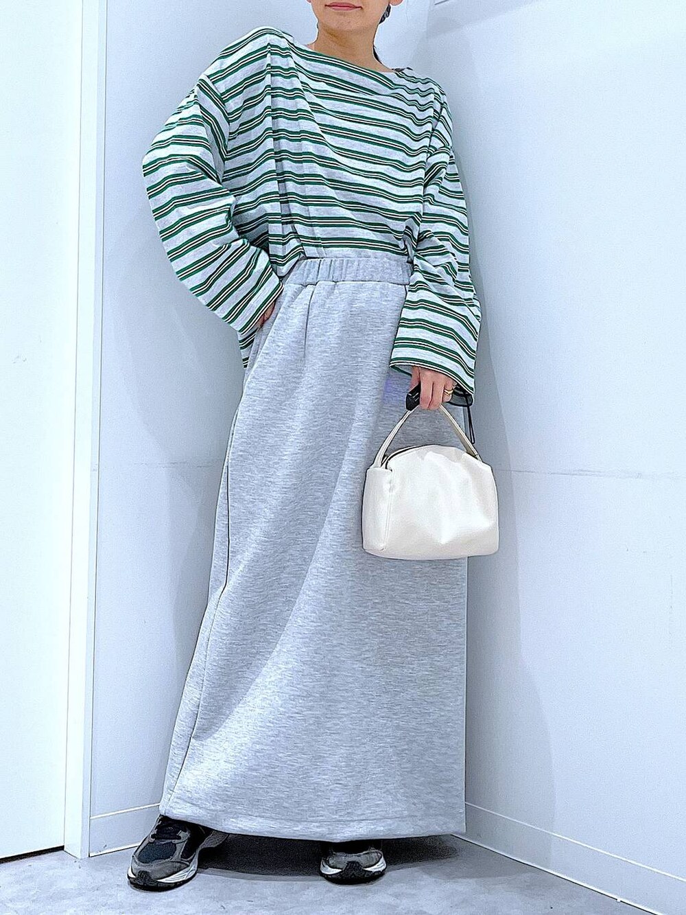ホワイト系のショルダーバッグ、グレー系のスカート、グレー系のTシャツ/カットソーを着用したレディースの春コーディネートの6枚目の写真
