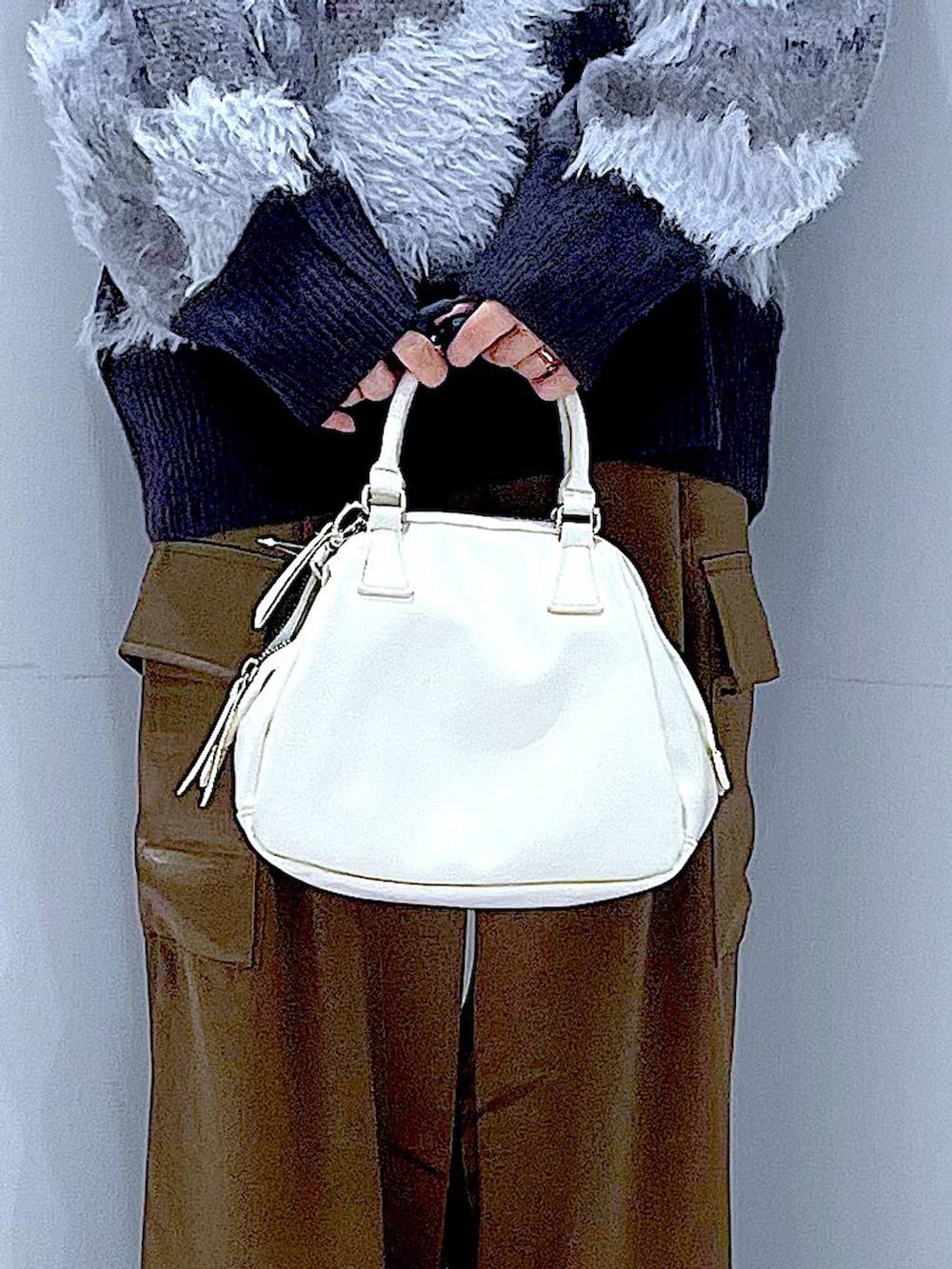 ブラック系のニット/セーター、ブラック系のブーツ、ブラック系のショルダーバッグを着用したレディースの秋コーディネートの9枚目の写真