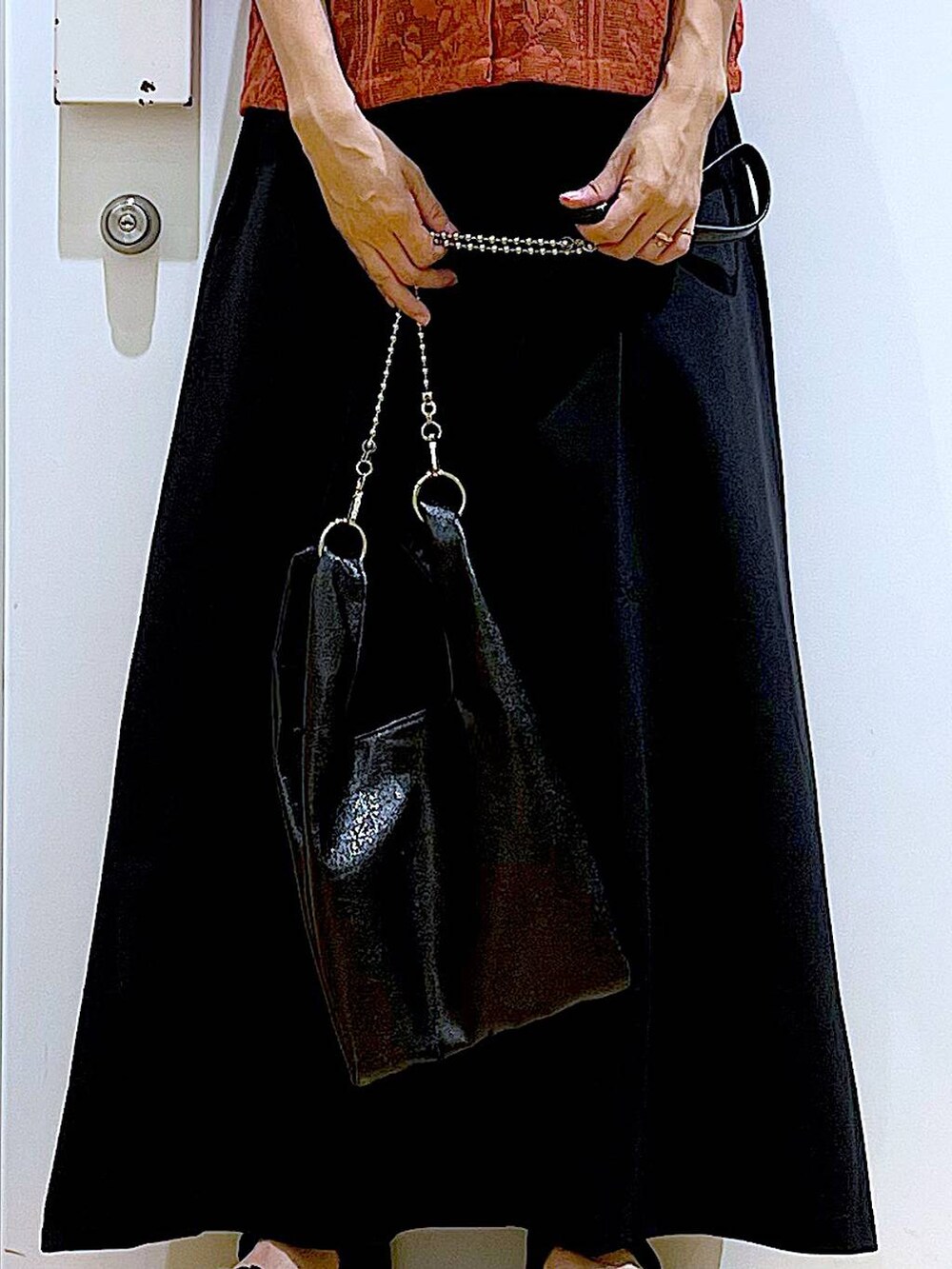 ブラック系のショルダーバッグ、レッド系のシャツ/ブラウス、ブラック系のスカートを着用したレディースの夏コーディネートの9枚目の写真