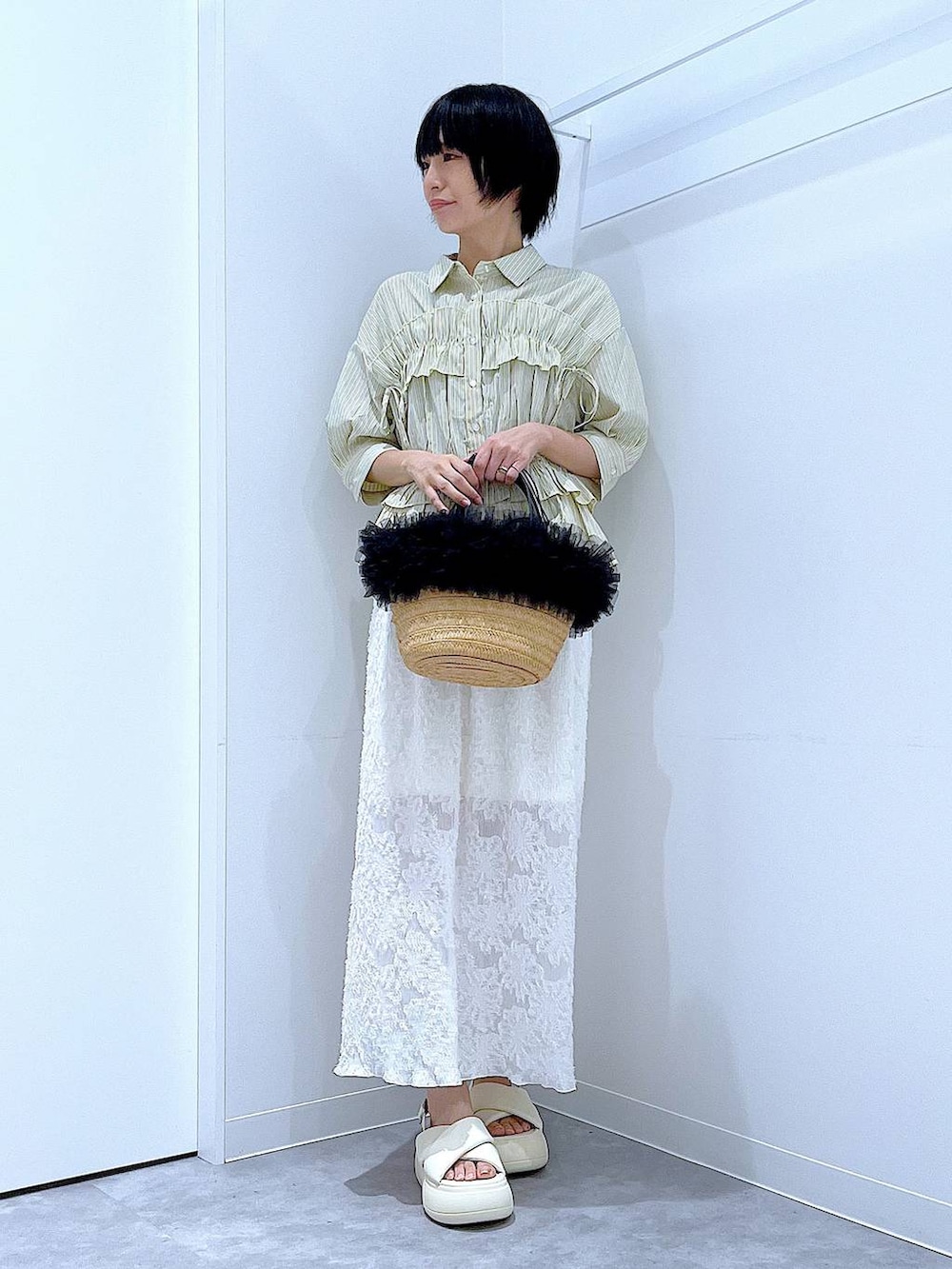 ベージュ系のショルダーバッグ、ホワイト系のサンダル、ホワイト系のスカートを着用したレディースの夏コーディネートの2枚目の写真