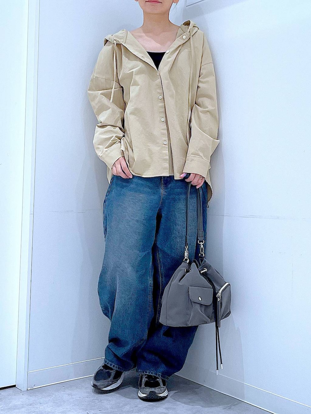 ブルー系のデニムパンツ、グレー系のショルダーバッグ、ベージュ系のその他トップスを着用したレディースの春コーディネートの6枚目の写真