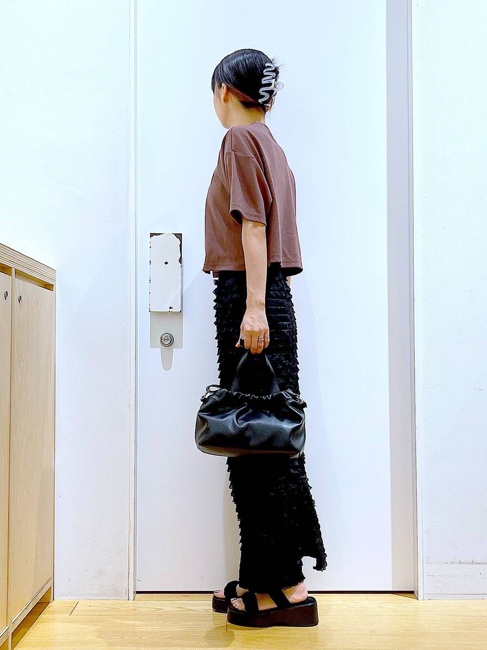 レッド系のワンピース、ブラック系のサンダル、ブラック系のショルダーバッグを着用したレディースの夏コーディネートの3枚目の写真