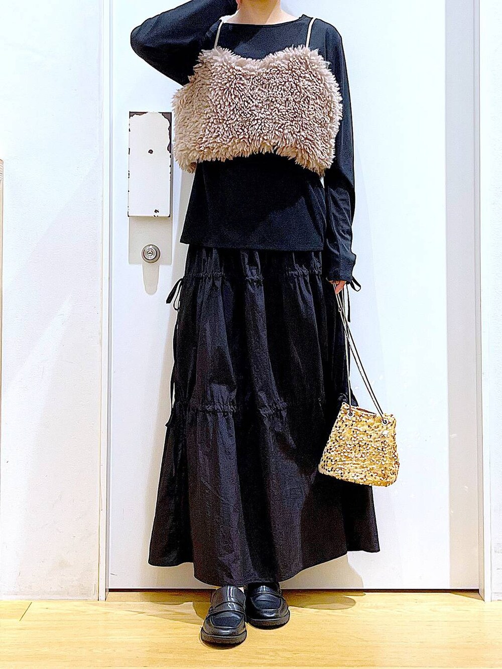 ブラウン系のベスト、ベージュ系のショルダーバッグ、ブラック系のTシャツ/カットソーを着用したレディースの秋コーディネートの6枚目の写真