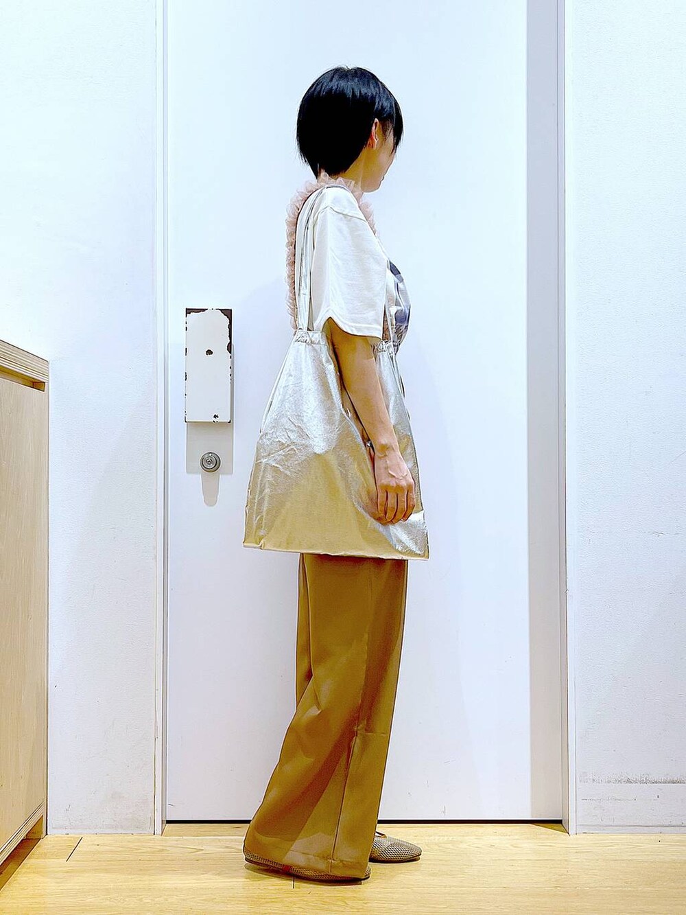 シルバー系のトートバッグ、ベージュ系のパンプス、ブラウン系のその他パンツを着用したレディースの春コーディネートの4枚目の写真