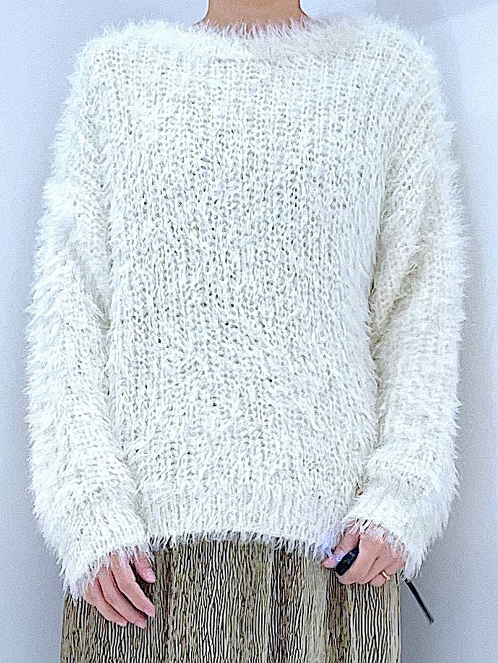 ベージュ系のハンドバッグ、ブラック系のブーツ、ベージュ系のニット/セーターを着用したレディースの冬コーディネートの7枚目の写真