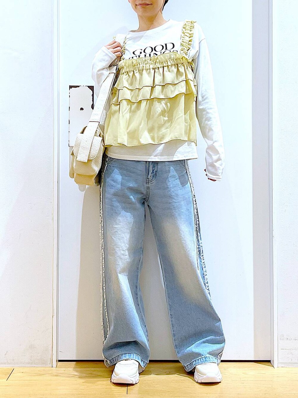 ホワイト系のスニーカー、ブルー系のデニムパンツ、ベージュ系のその他トップスを着用したレディースの春コーディネートの6枚目の写真