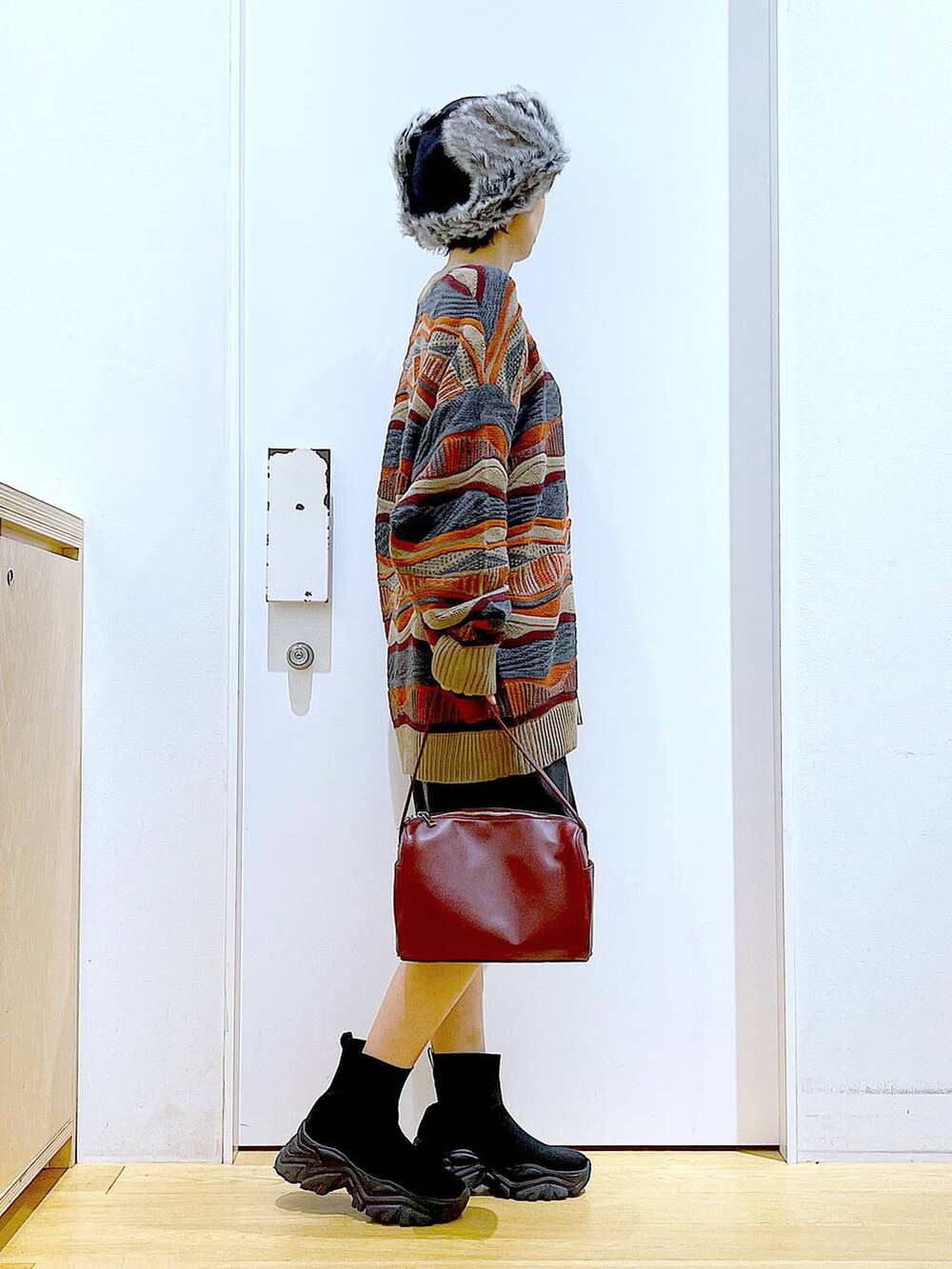 レッド系のショルダーバッグ、ブラック系のブーツ、ブラック系のその他パンツを着用したレディースの冬コーディネートの4枚目の写真