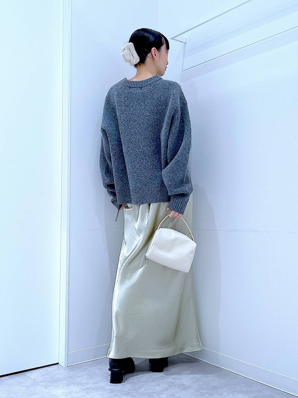 ブラック系のブーツ、グレー系のニット/セーター、ホワイト系のショルダーバッグを着用したレディースの冬コーディネートの5枚目の写真