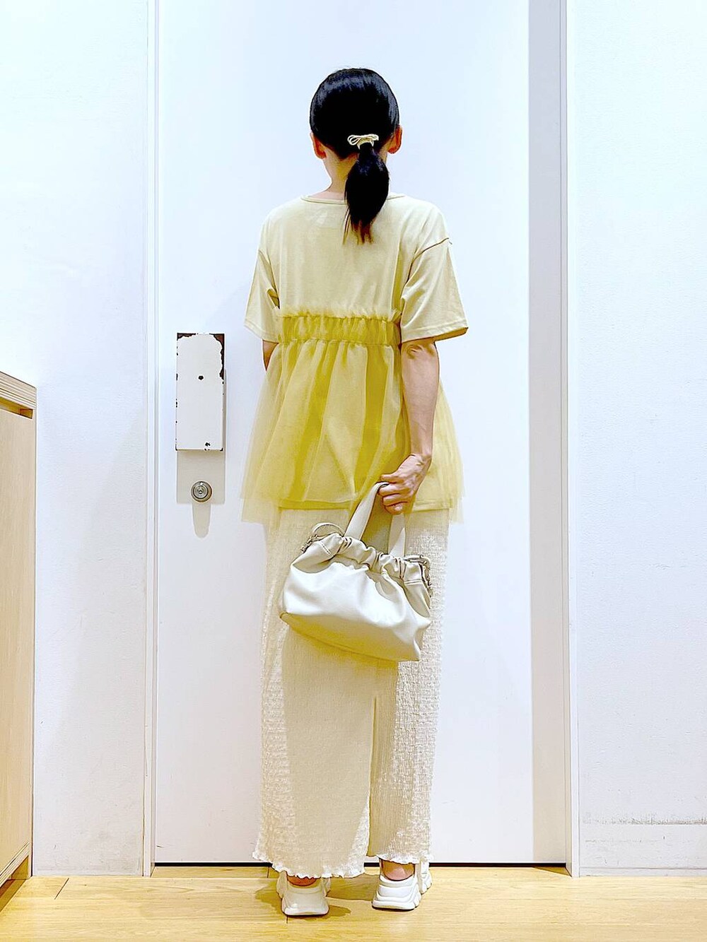 ホワイト系のサンダル、ベージュ系のスカート、イエロー系のTシャツ/カットソーを着用したレディースの夏コーディネートの5枚目の写真