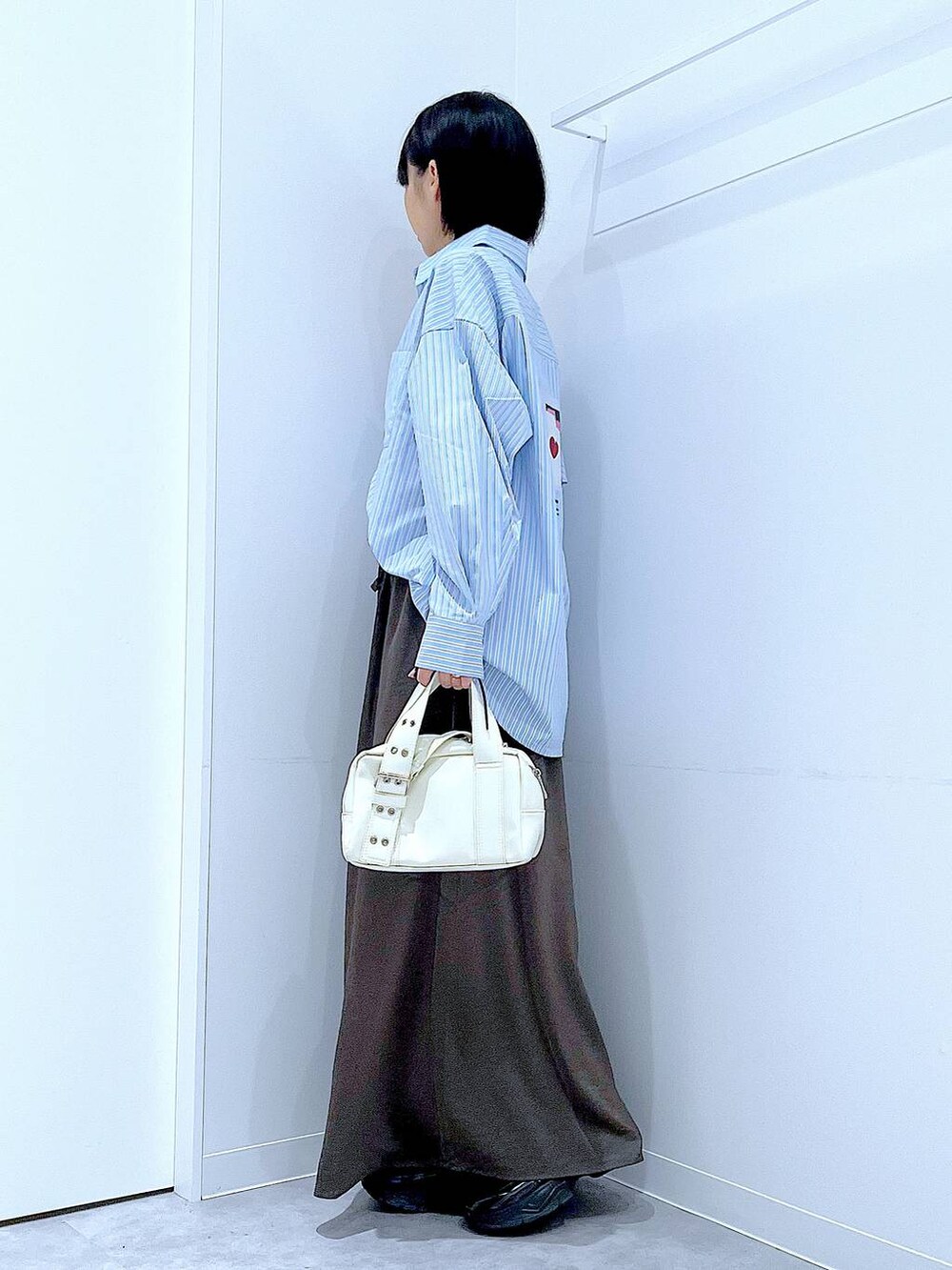 ブラック系のローファー、ホワイト系のショルダーバッグ、グレー系のスカートを着用したレディースの秋コーディネートの3枚目の写真