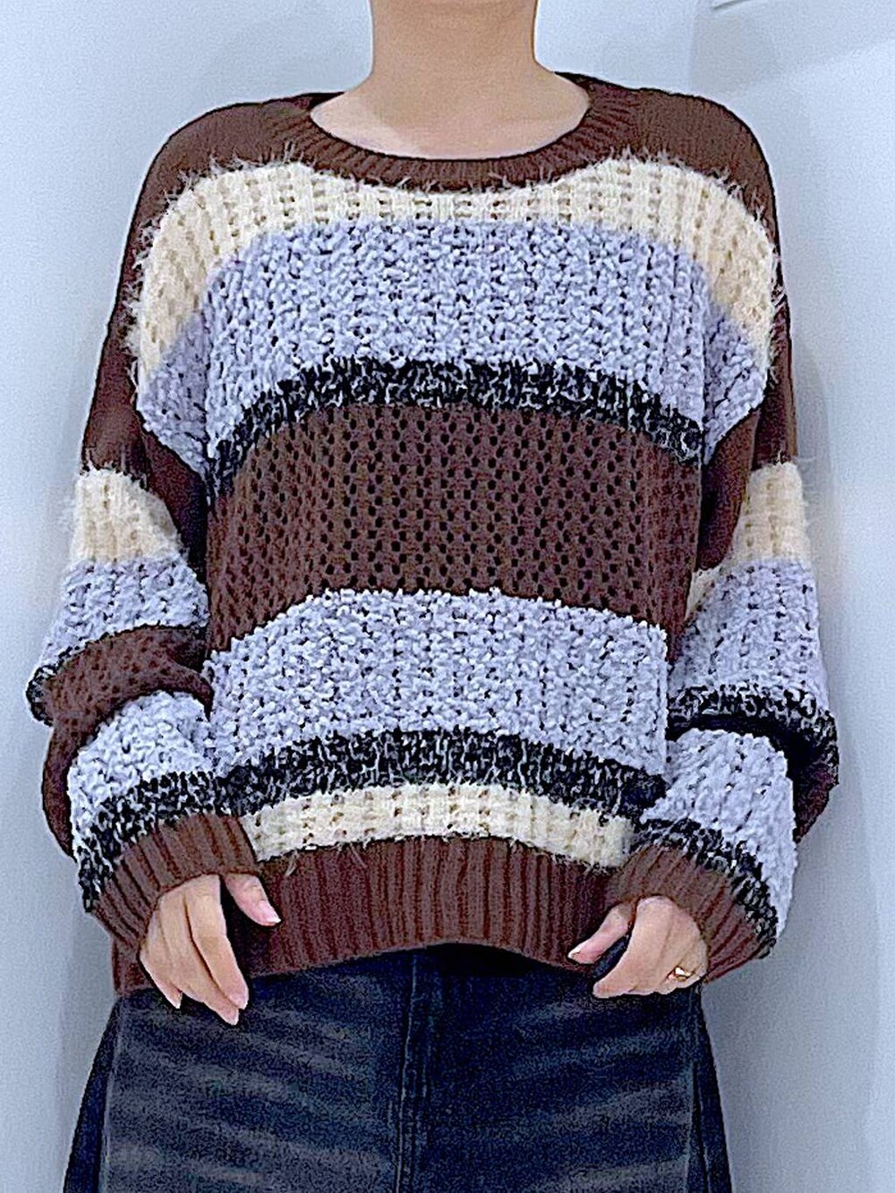 ブラック系のデニムパンツ、ブラック系のショルダーバッグ、ブラウン系のニット/セーターを着用したレディースの秋コーディネートの7枚目の写真