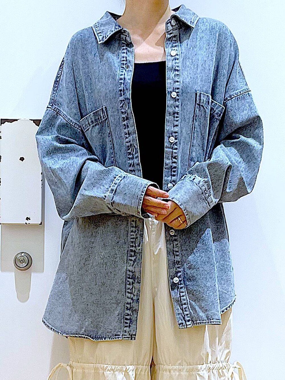 ブラック系のショルダーバッグ、シルバー系のパンプス、ブルー系のシャツ/ブラウスを着用したレディースの秋コーディネートの7枚目の写真