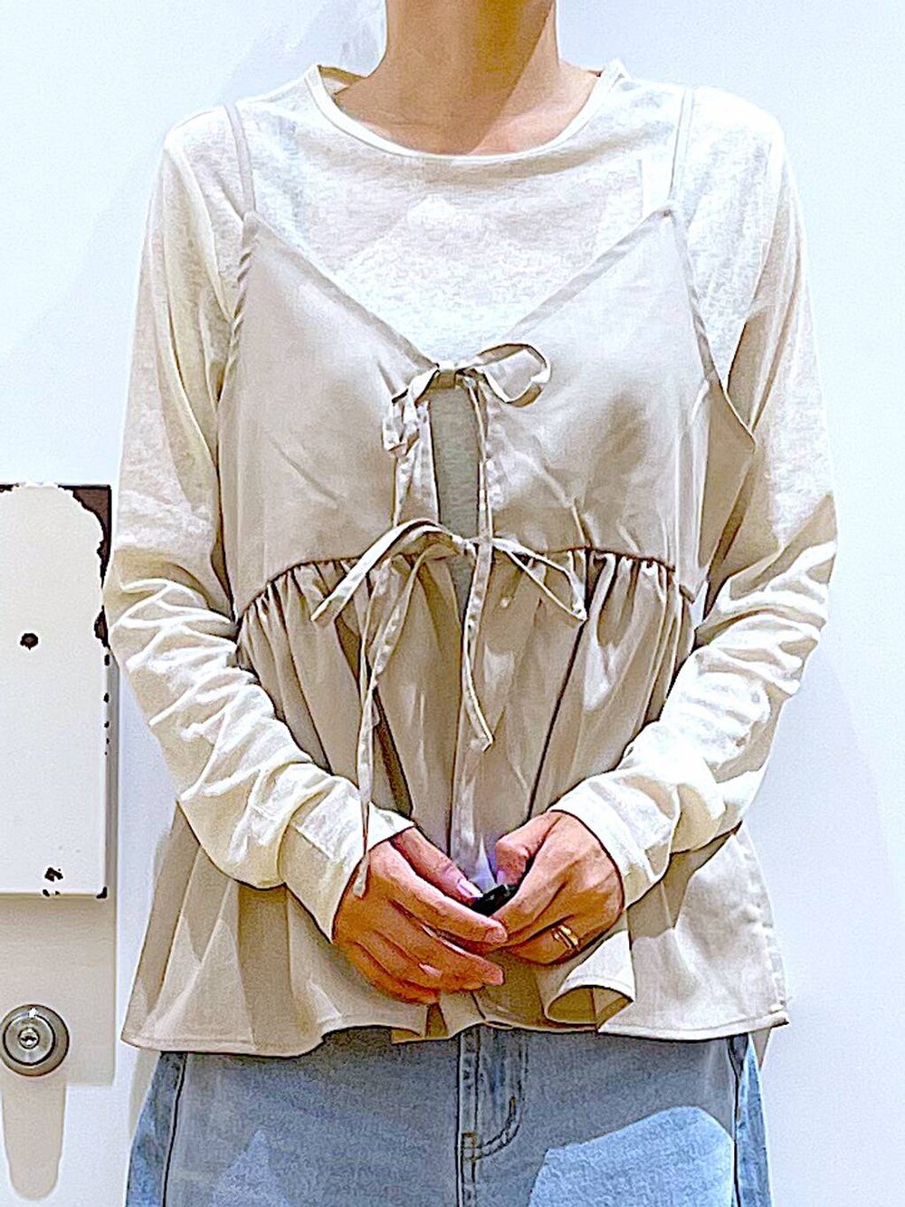 ブルー系のデニムパンツ、シルバー系のローファー、ホワイト系のトートバッグを着用したレディースの秋コーディネートの7枚目の写真
