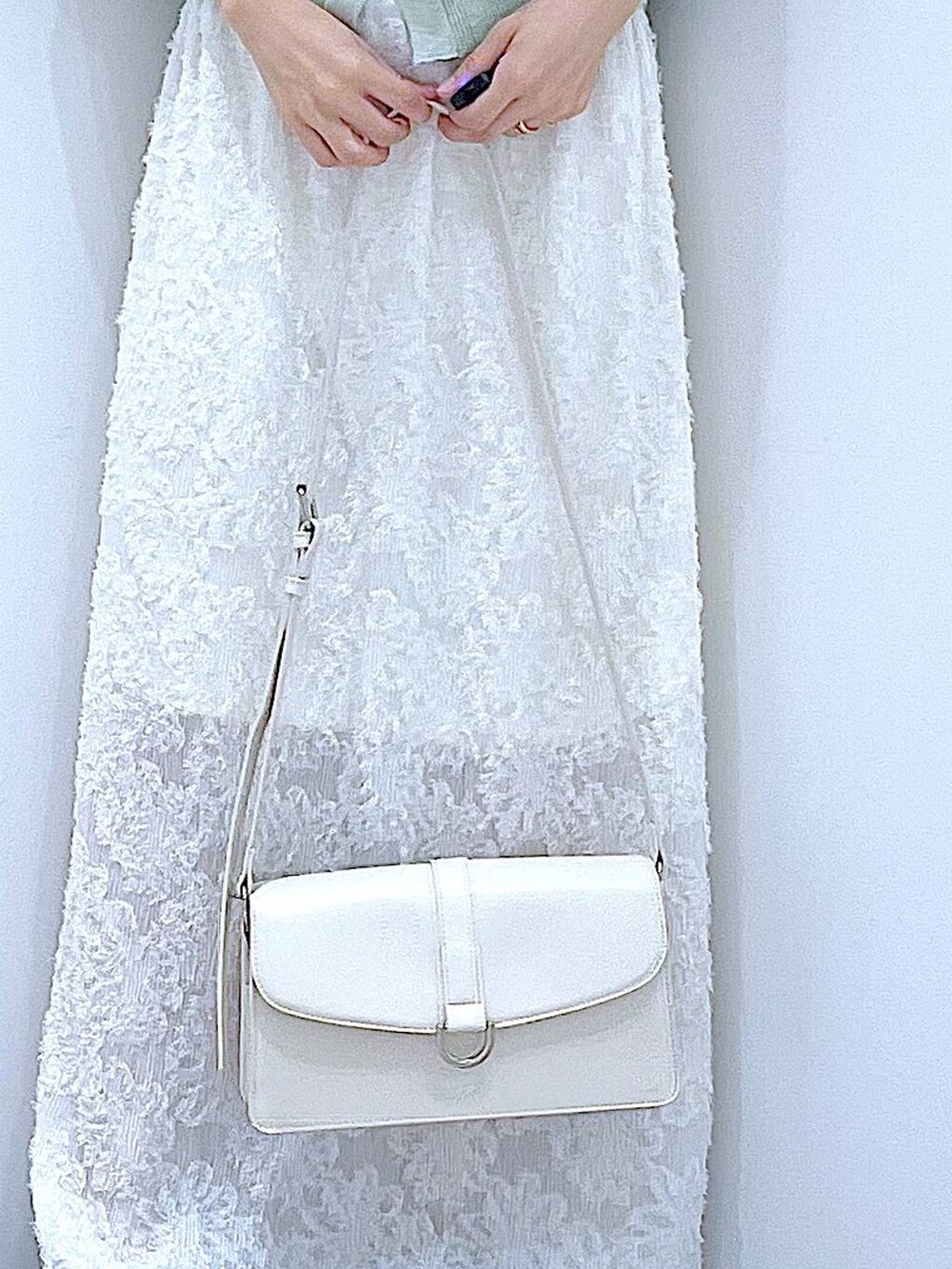 ブラック系のサンダル、ホワイト系のスカート、グリーン系のカーディガン/ボレロを着用したレディースの夏コーディネートの9枚目の写真