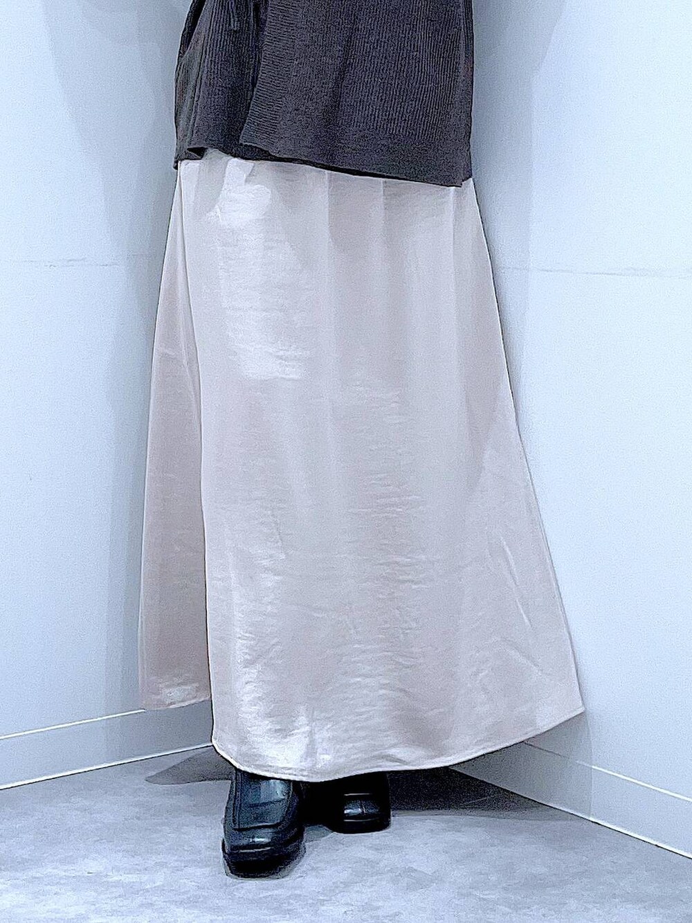 ホワイト系のハンドバッグ、ベージュ系のスカート、ブラック系のブーツを着用したレディースの秋コーディネートの8枚目の写真