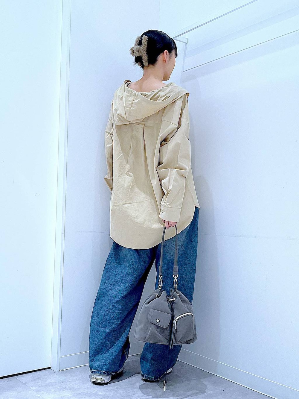 ブルー系のデニムパンツ、グレー系のショルダーバッグ、ベージュ系のその他トップスを着用したレディースの春コーディネートの5枚目の写真