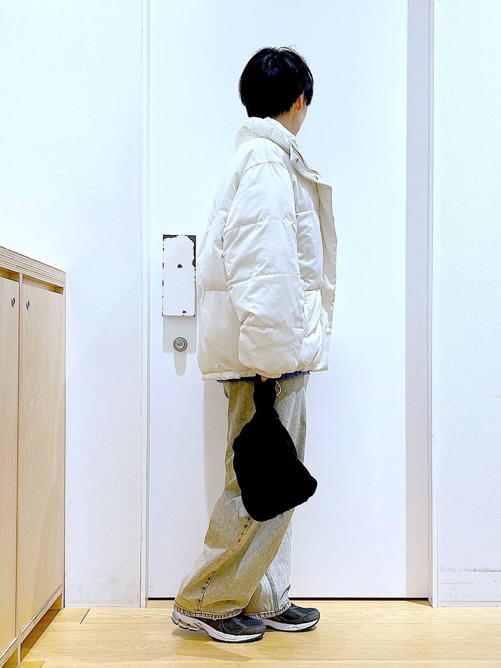 ベージュ系のブルゾン、ブラック系のショルダーバッグ、ベージュ系のデニムパンツを着用したレディースの冬コーディネートの4枚目の写真