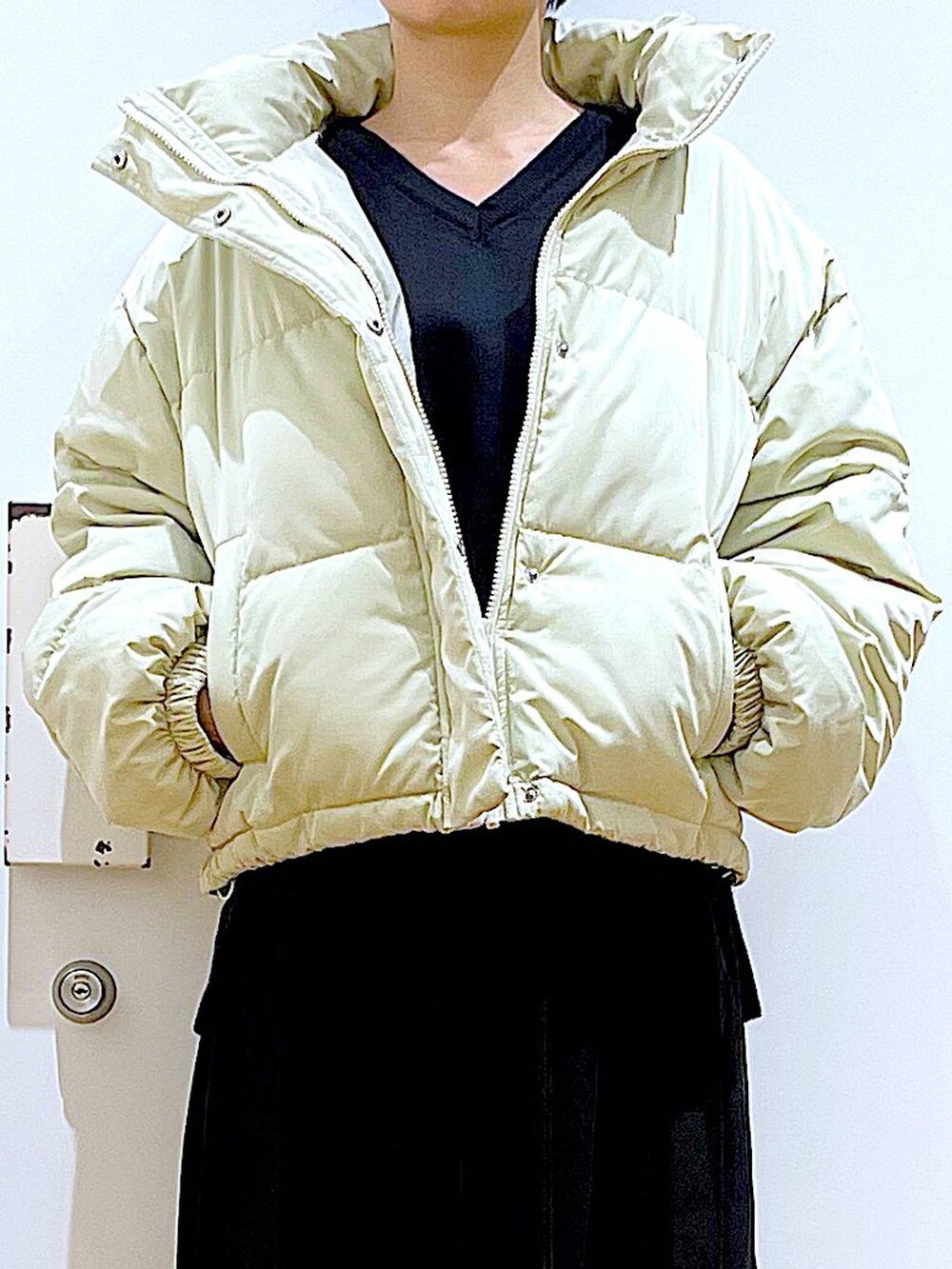 イエロー系のブルゾン、ブラック系のブーツ、ブラック系のスカートを着用したレディースの冬コーディネートの7枚目の写真