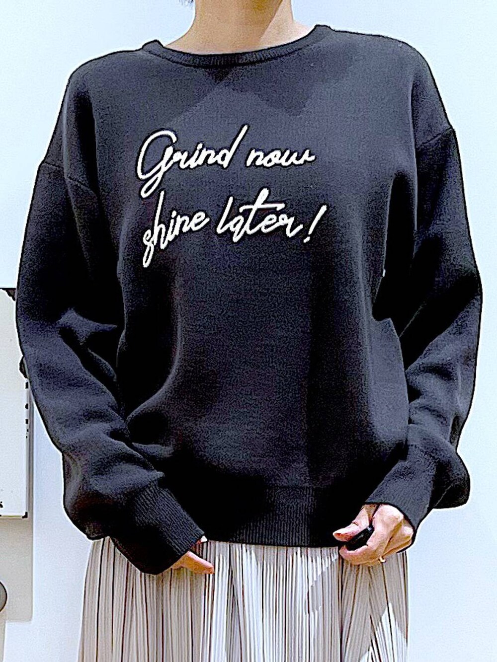 ブラック系のショルダーバッグ、ブラック系のスニーカー、グレー系のニット/セーターを着用したレディースの夏コーディネートの7枚目の写真