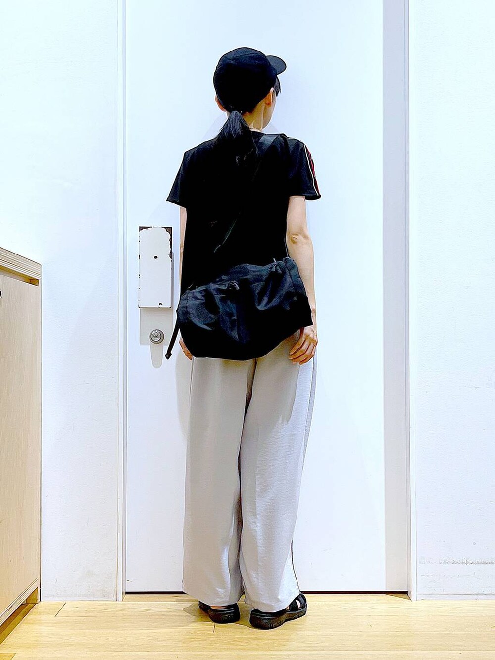 ブラック系のショルダーバッグ、ブラック系のスリッポン、ブラック系のTシャツ/カットソーを着用したレディースの春コーディネートの5枚目の写真