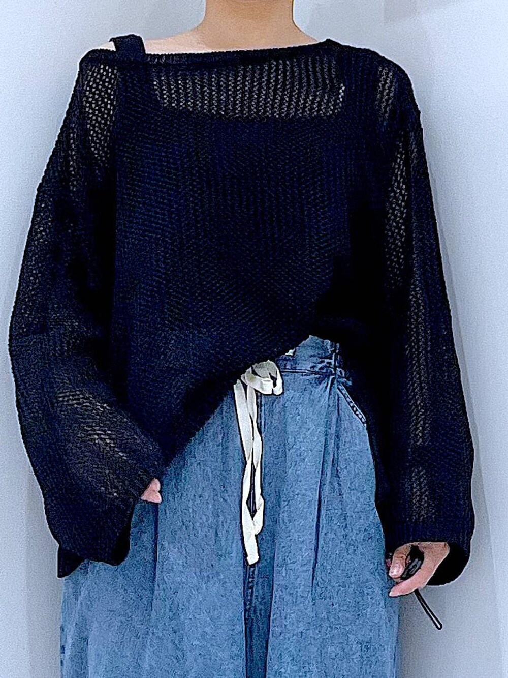 ブラック系のブーツ、ブラック系のニット/セーター、ブルー系のショルダーバッグを着用したレディースの春コーディネートの7枚目の写真