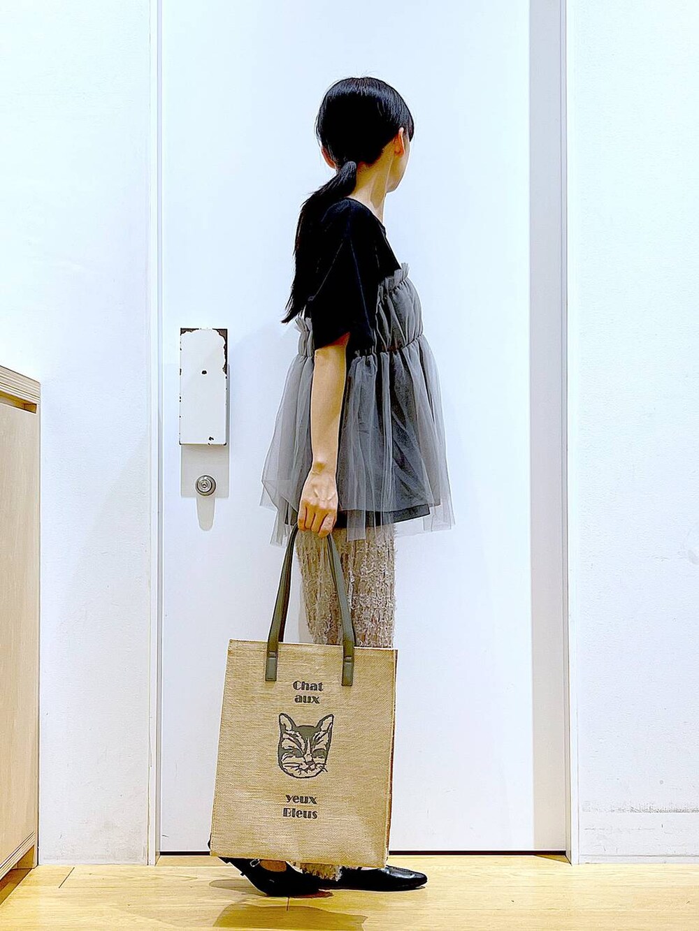 ブラック系のTシャツ/カットソー、ブラック系のパンプス、グレー系のトートバッグを着用したレディースの夏コーディネートの4枚目の写真