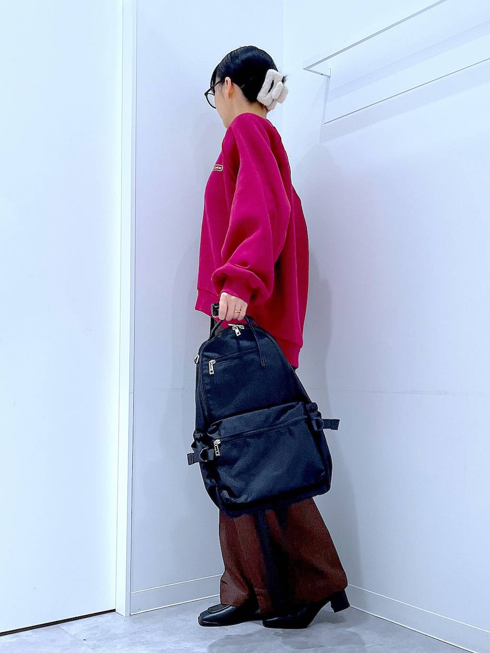 ブラック系のブーツ、ブラウン系のスラックス、ブラック系のバックパック/リュックを着用したレディースの冬コーディネートの3枚目の写真