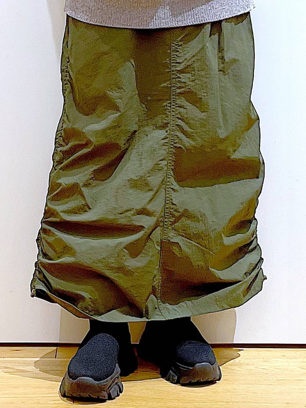 ブラック系のブーツ、グレー系のニット/セーター、グリーン系のスカートを着用したレディースの冬コーディネートの8枚目の写真