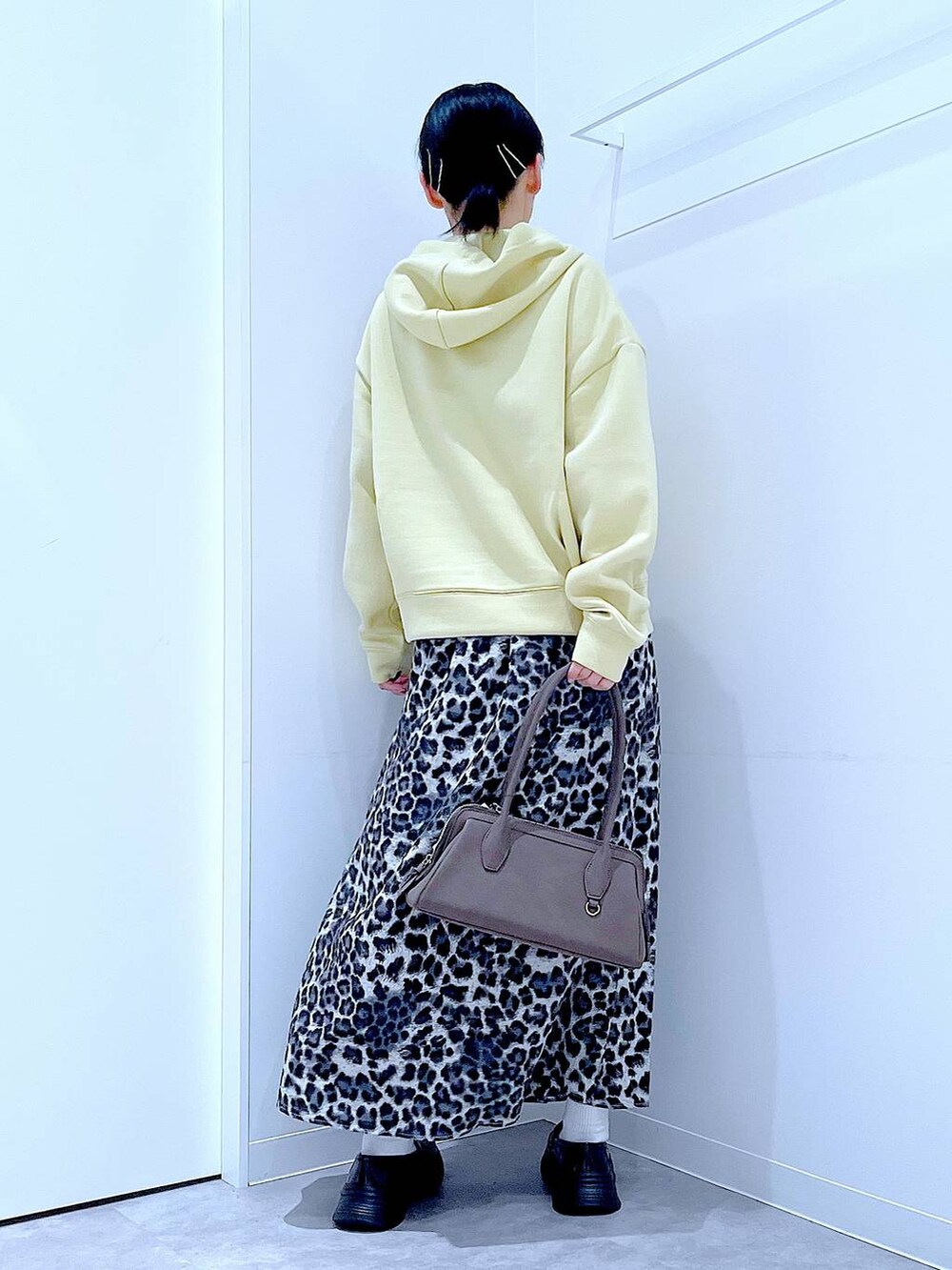 ブラック系のローファー、グレー系のスカート、イエロー系のパーカーを着用したレディースの秋コーディネートの5枚目の写真