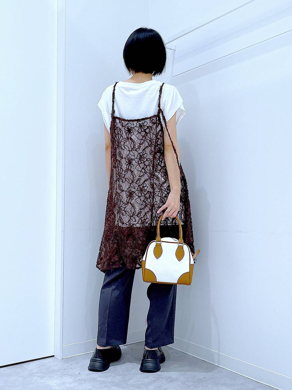 ホワイト系のTシャツ/カットソー、ブラック系のローファー、ベージュ系のチュニックを着用したレディースの夏コーディネートの5枚目の写真