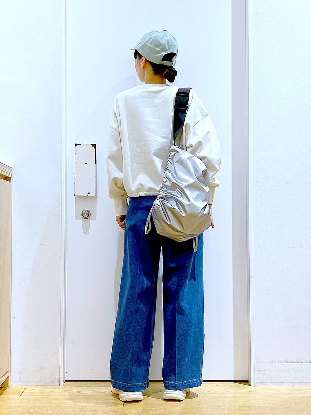 ホワイト系のスウェット、ブルー系のデニムパンツ、ベージュ系のスニーカーを着用したレディースの冬コーディネートの5枚目の写真