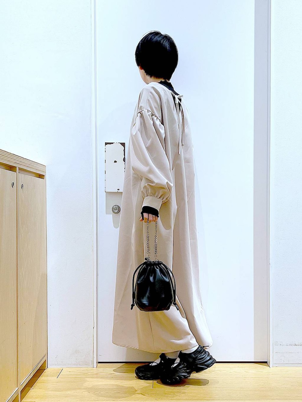 ブラック系のTシャツ/カットソー、ブラック系のショルダーバッグ、ブラック系のスニーカーを着用したレディースの春コーディネートの3枚目の写真