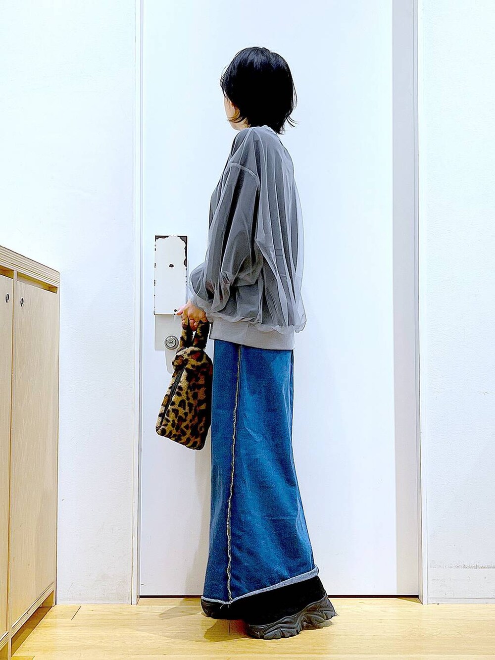 その他のショルダーバッグ、ブルー系のデニムスカート、ブラック系のブーツを着用したレディースの冬コーディネートの3枚目の写真