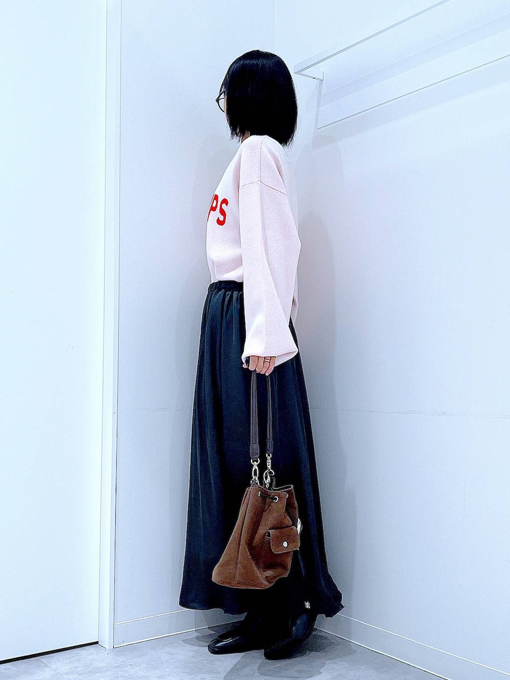 ブラウン系のショルダーバッグ、ブラック系のブーツ、ベージュ系のニット/セーターを着用したレディースの冬コーディネートの3枚目の写真