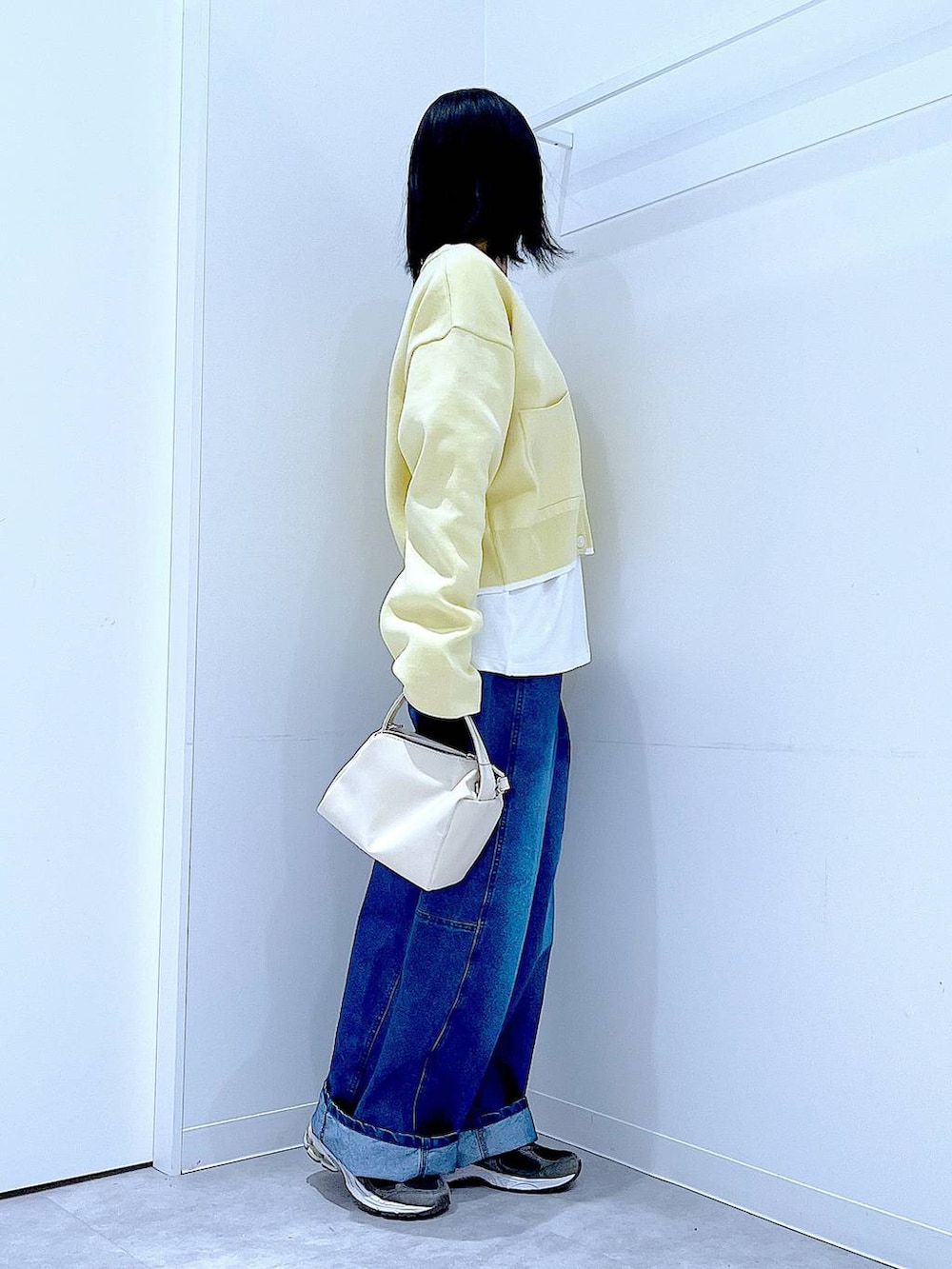 ホワイト系のショルダーバッグ、ホワイト系のTシャツ/カットソー、ブルー系のデニムパンツを着用したレディースの春コーディネートの4枚目の写真