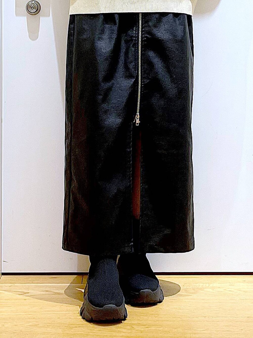 ブラック系のスカート、ブラック系のブーツ、ピンク系のショルダーバッグを着用したレディースの冬コーディネートの8枚目の写真